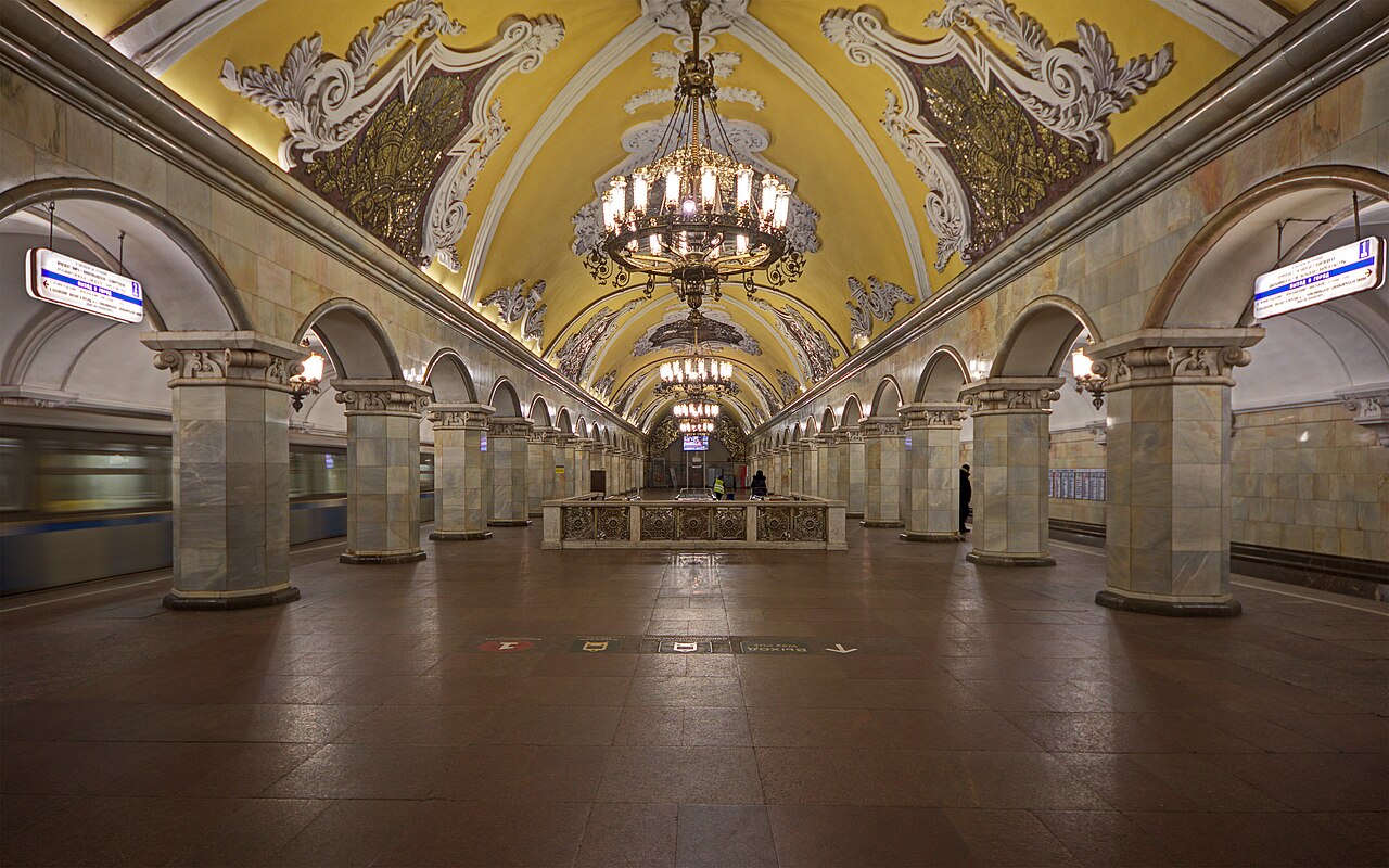 The vaulted, chandelier-lit hall of Komsomolskaya metro station in Moscow.