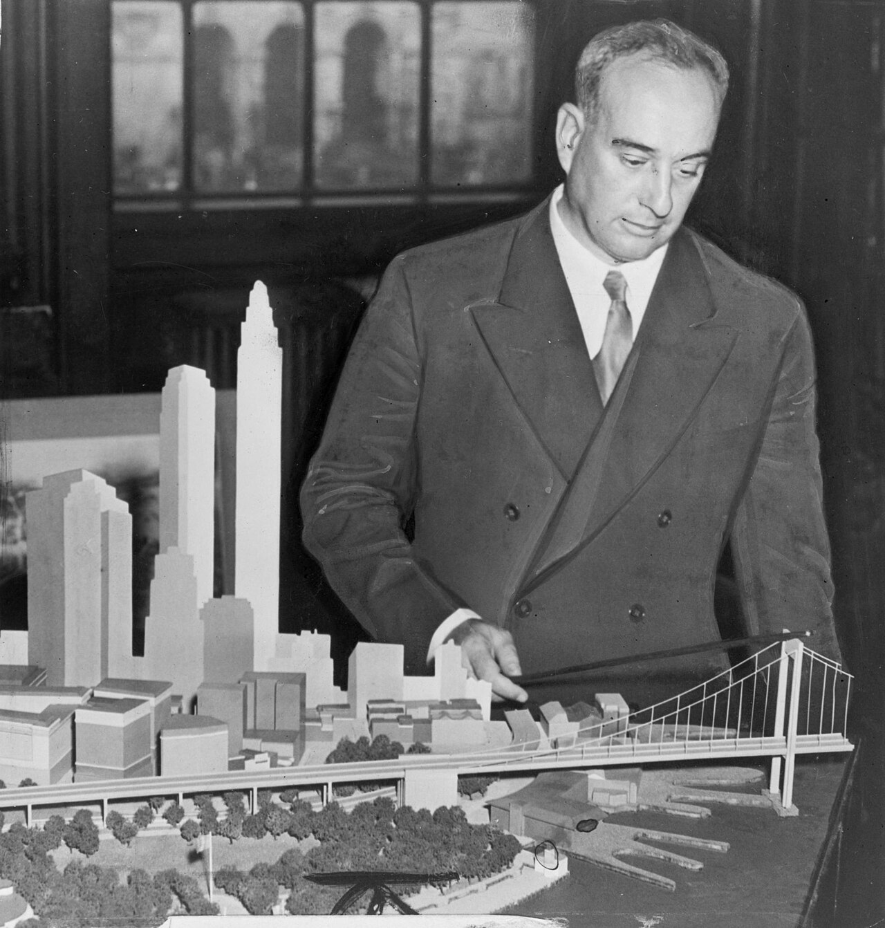 Robert Moses points at a model of his proposed Battery Bridge in 1939.